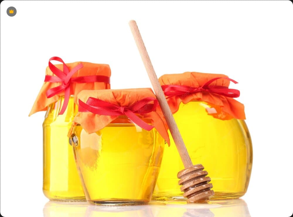 Jars of natural honey with a wooden dipper